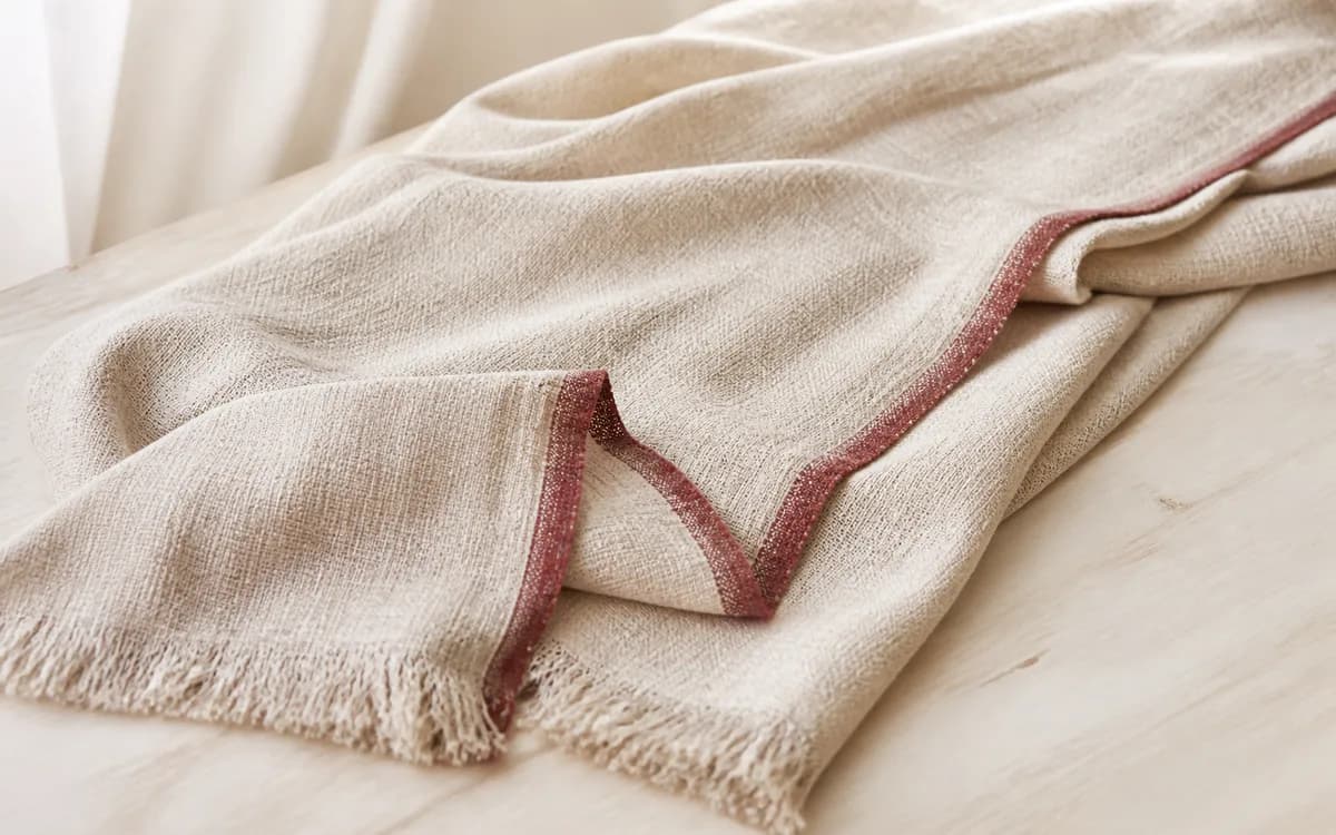 Editorial still life of a woven throw, representing home textiles sourcing in Jaipur, Rajasthan